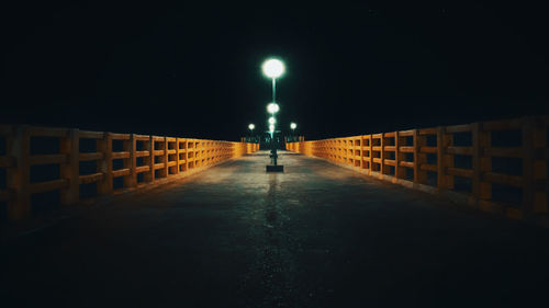 Man walking on illuminated street at night