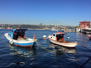 Boats moored on sea against clear sky