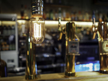 Close-up of illuminated light bulb against counter in bar