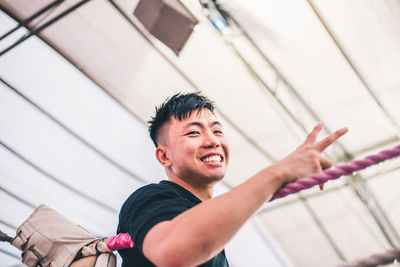 Portrait of man gesturing while standing in boxing ring