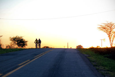 Rear view of man riding motorcycle on road against sky