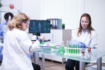 Portrait of female doctor examining chemical in laboratory