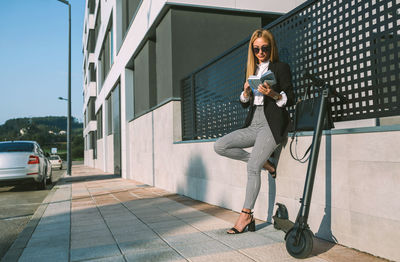 Young woman using mobile phone while standing outdoors
