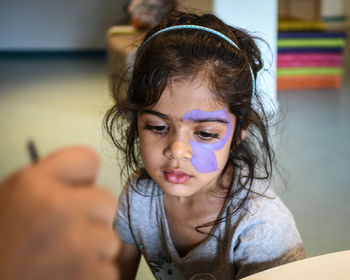 Close-up of girl with purple paint on face