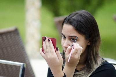 Portrait of young woman using mobile phone outdoors