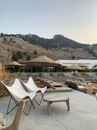 Chairs and tables on mountain against clear sky