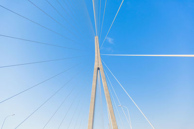 Low angle view of suspension bridge against clear blue sky