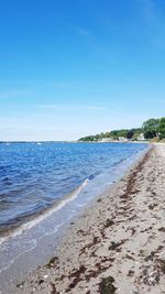 Scenic view of beach against blue sky