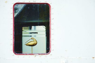 Golden bird figurine seen through boat window