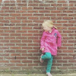 Woman sitting on brick wall