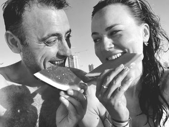 Smiling couple eating watermelon