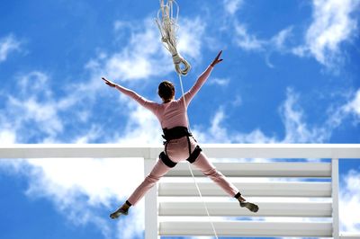 Low angle view of man paragliding against sky