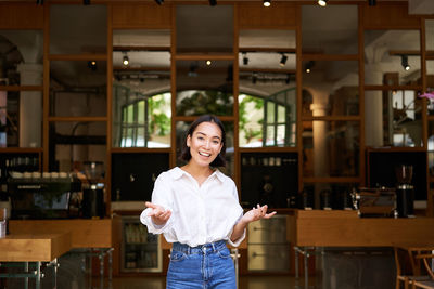 Portrait of young woman standing in store