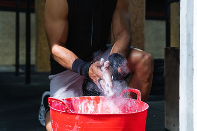 Midsection of man washing in workshop