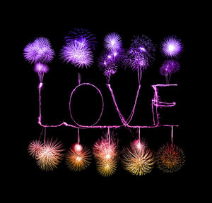 Illuminated firework display over black background