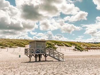 Lifeguard hut on beach against sky