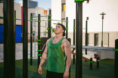 Muscular man exercising against sky at park