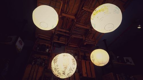 Low angle view of illuminated pendant light hanging from ceiling