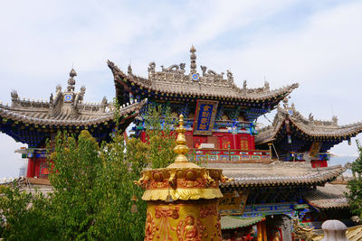 Temple by building against sky