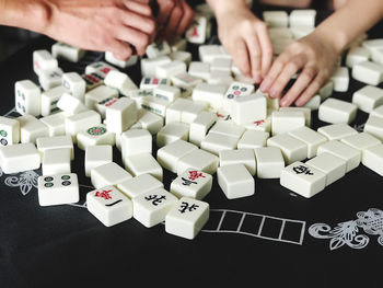 Cropped hand of man holding toy blocks on table