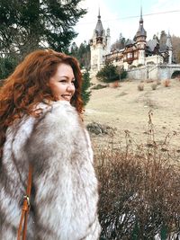 Close-up of woman against building during winter