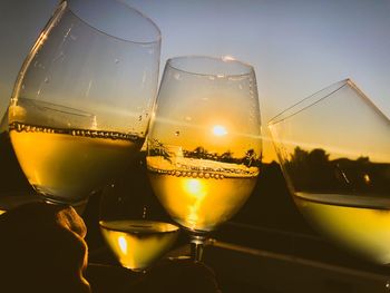 Close-up of wine glass on table at sunset