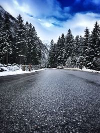 Snow covered landscape against cloudy sky