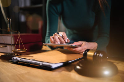 Midsection of man using smart phone on table