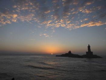 Scenic view of sea against cloudy sky during sunset