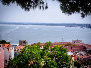 High angle view of townscape by sea against sky