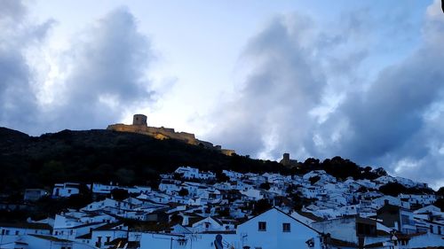 Houses on mountain against sky