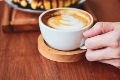 Midsection of coffee cup on table