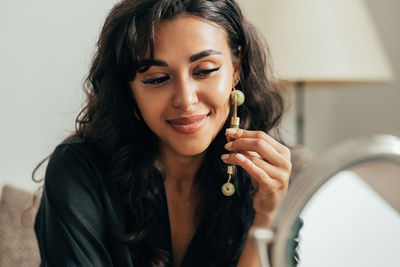 Close-up of young smiling woman wearing earring