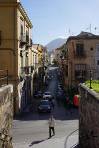 Street amidst buildings in city against sky