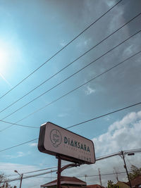 Low angle view of road sign against sky