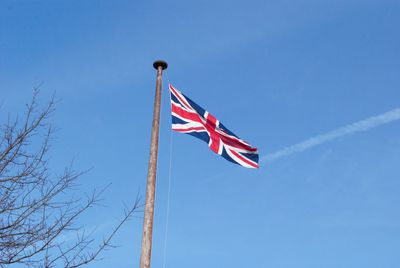 Low angle view of flag against clear blue sky