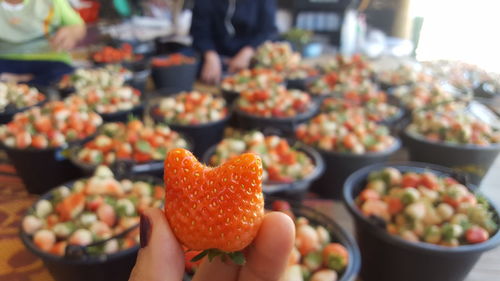 Close-up of hand holding strawberry at market