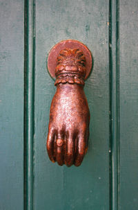 Close-up of rusty antique knocker on metal door