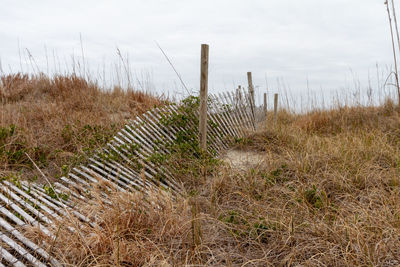 Fence on field against sky