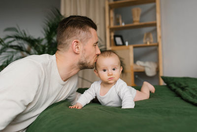 Father and baby at home on the bed together, bedtime