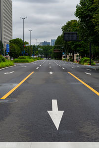 Arrow sign on road in city