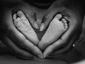 Cropped hands of father holding baby feet