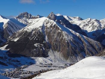 Scenic view of snowcapped mountains against clear blue sky