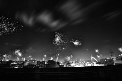 Low angle view of fireworks against sky at night