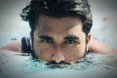 Close-up portrait of young man swimming in pool