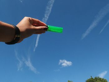 Low angle view of human hand against clear blue sky