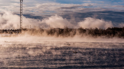 Scenic view of lake against sky during foggy weather