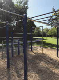 Metal fence on field against trees in park