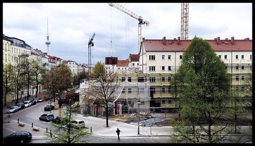 Buildings in city against cloudy sky