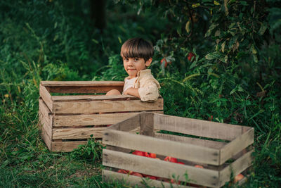 Side view of young woman sitting on wood